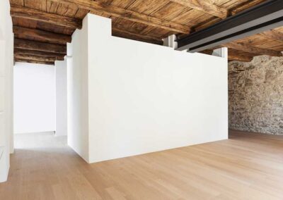 Appartamento rustico ristrutturato con travi a vista, pareti bianche e parquet